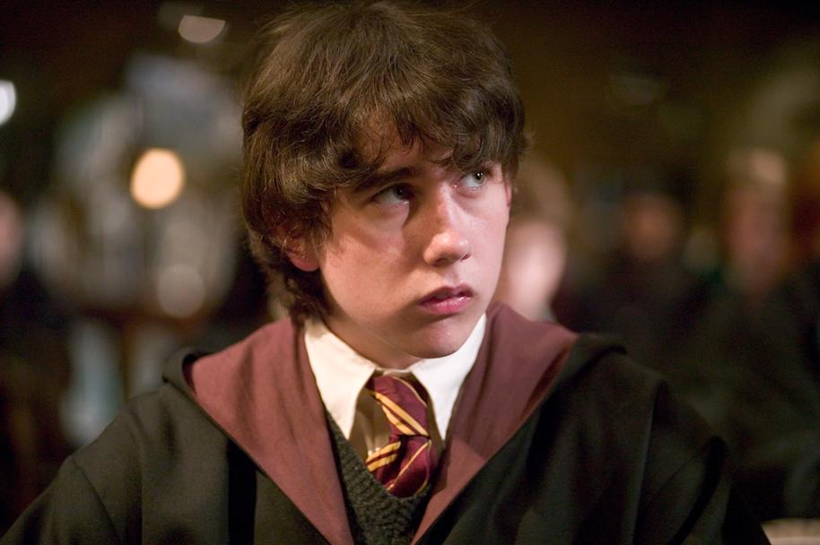 A close up of Neville Longbottom sitting in a class and looking concerned.